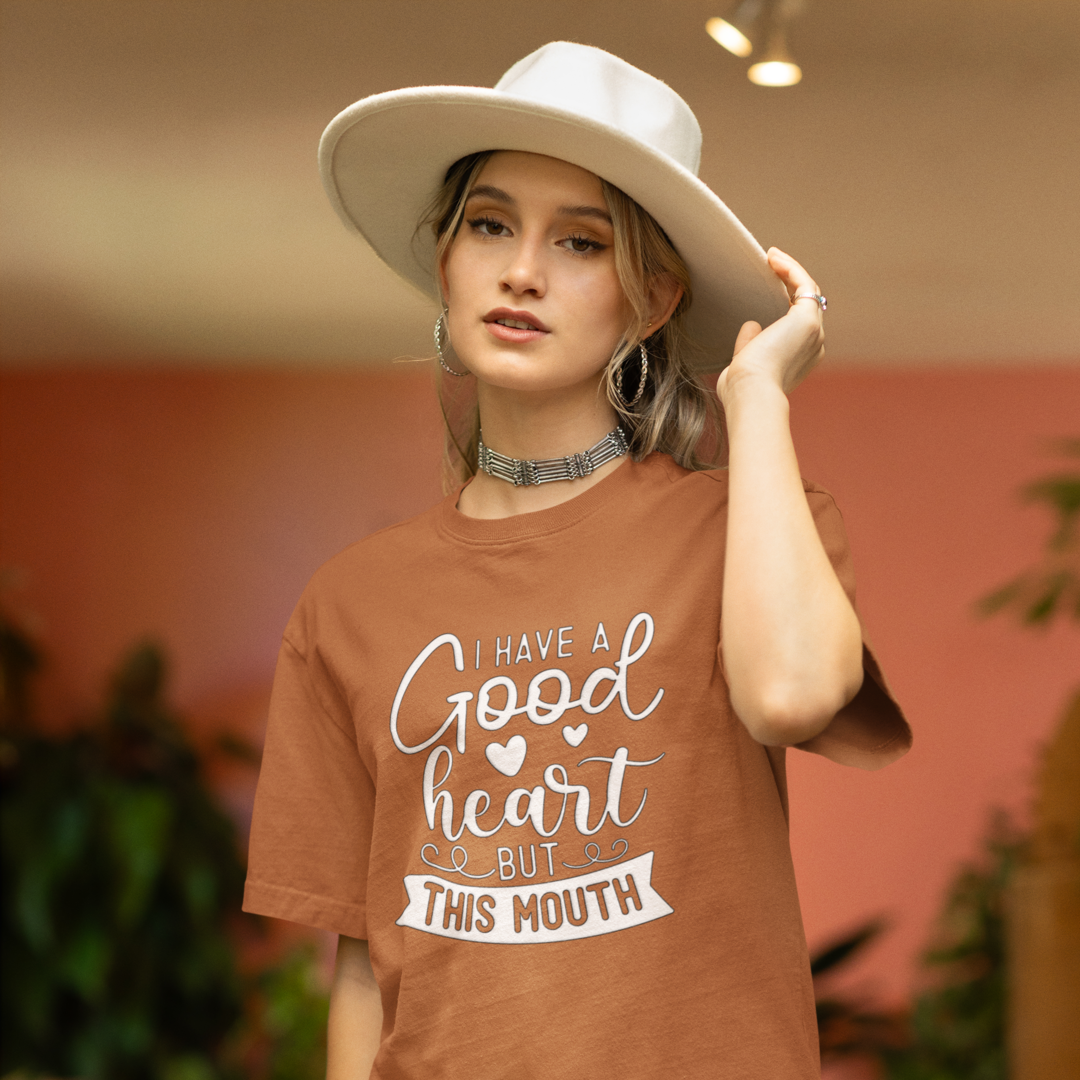 A Woman With a White Hat Wearing A Crew Neck T-Shirt with Text - "I Have a Good Heart, But This Mouth" - Toast